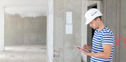 Digitale Bauabnahme: Bauleiter prüft Leistungen und dokumentiert Abnahmepunkte mit Tablet direkt auf der Baustelle.